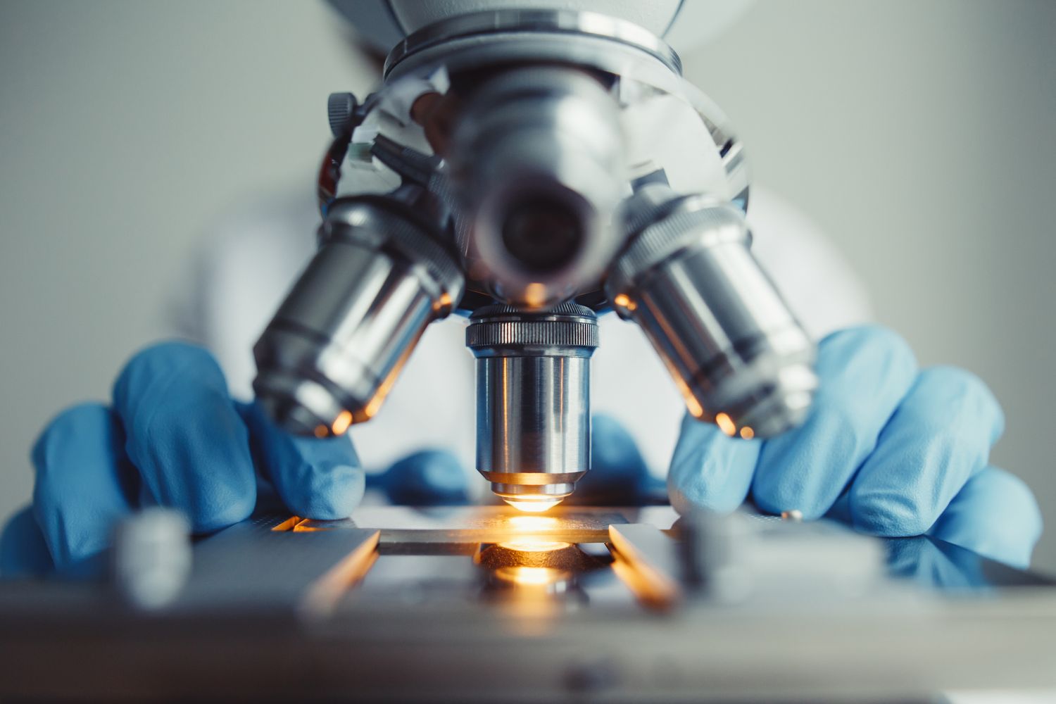 Microscope being operated in a laboratory setting.