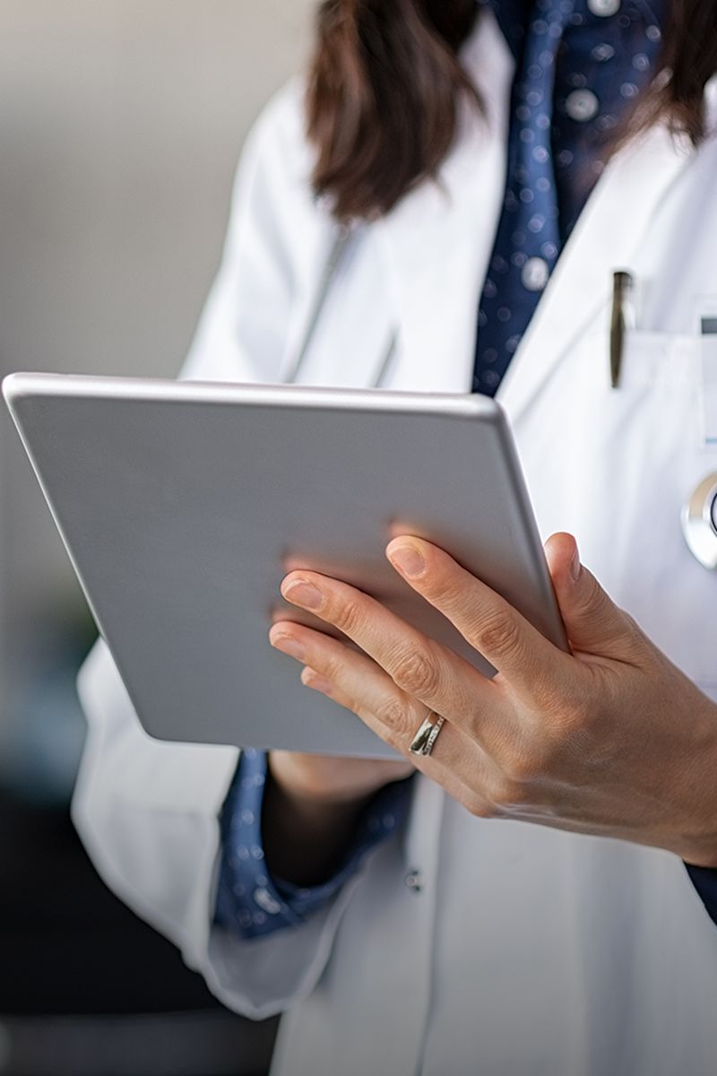 Healthcare professional using a tablet device.